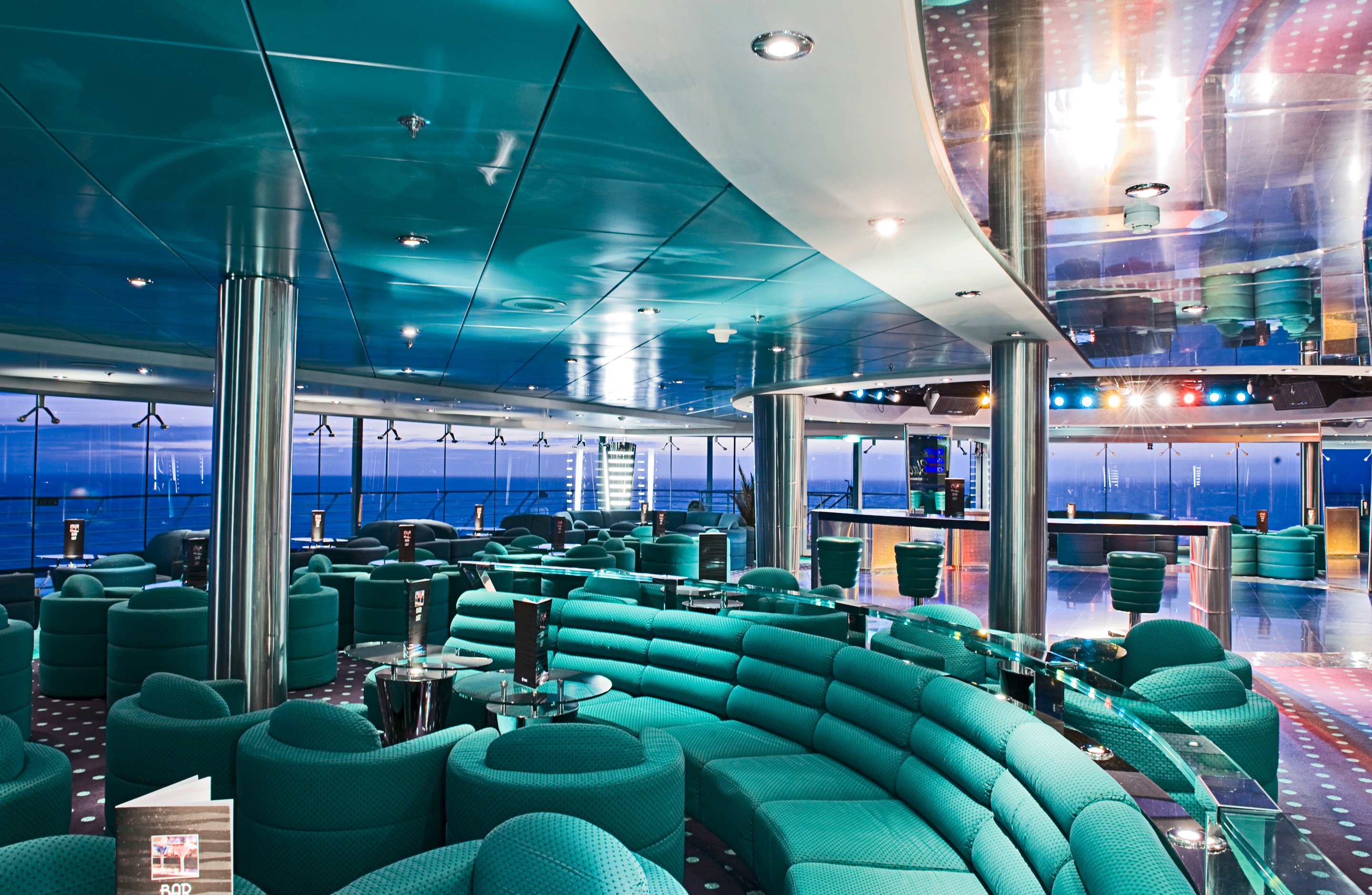 Elegant lounge with panoramic ocean views and modern seating on an MSC cruise ship | MSC Cruises Elegant lounge with panoramic ocean views and modern seating on an MSC cruise ship | MSC Cruises