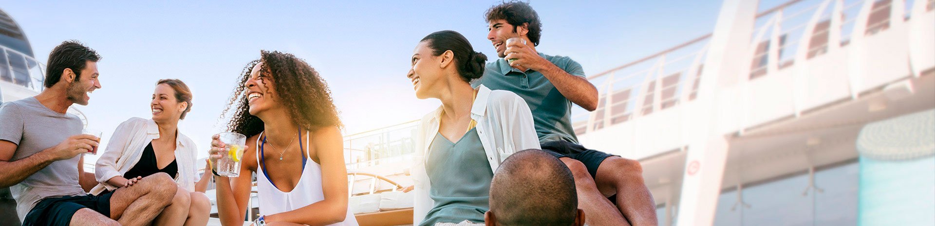 Guests enjoying drinks and conversation on a sunlit cruise ship deck | MSC Cruises Guests enjoying drinks and conversation on a sunlit cruise ship deck | MSC Cruises