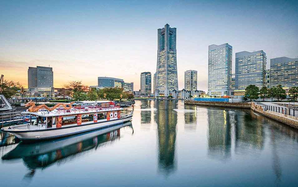 A dragon-themed boat with skyscrapers and waterfront at sunset in Yokohama, Japan | MSC Cruises A dragon-themed boat with skyscrapers and waterfront at sunset in Yokohama, Japan | MSC Cruises