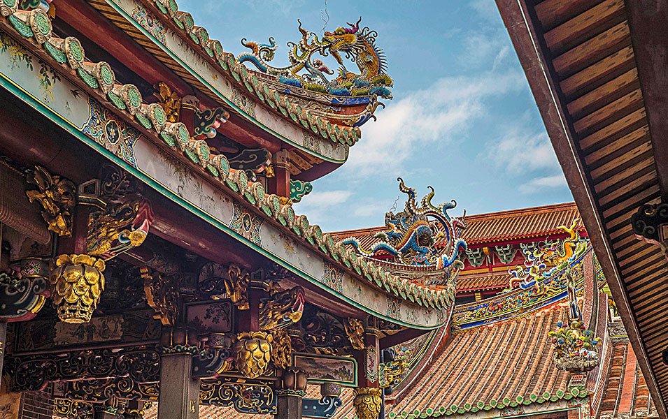 Intricate dragon-adorned temple roof under a bright sky in Asia | MSC Cruises Intricate dragon-adorned temple roof under a bright sky in Asia | MSC Cruises