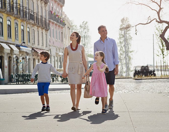 A family walking in a vibrant port city with colorful buildings | MSC Cruises A family walking in a vibrant port city with colorful buildings | MSC Cruises