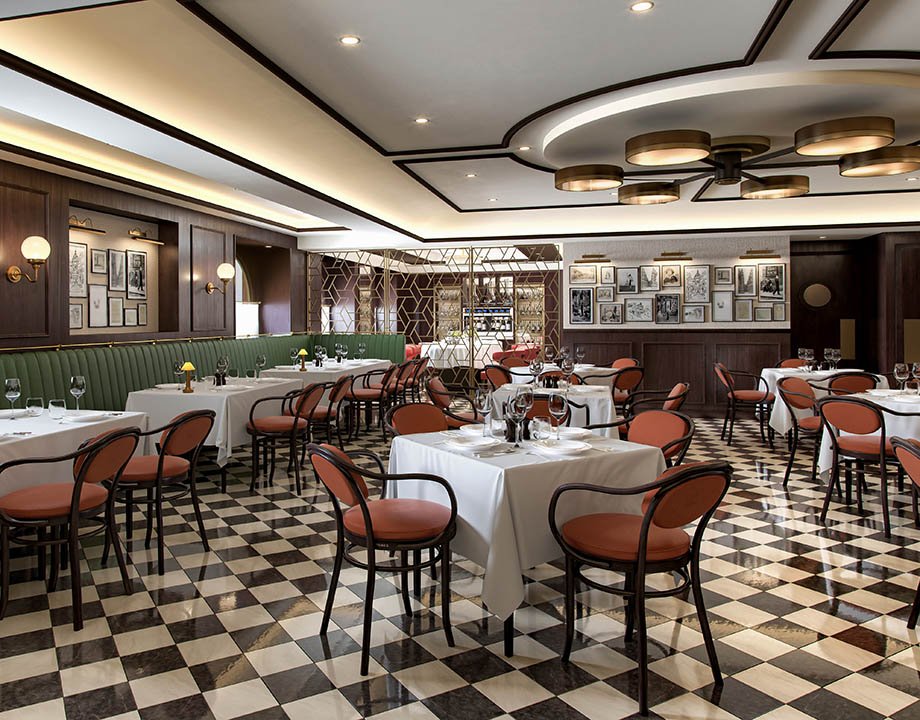 Elegant onboard restaurant with checkered flooring, white tablecloths, and warm lighting | MSC Cruises Elegant onboard restaurant with checkered flooring, white tablecloths, and warm lighting | MSC Cruises