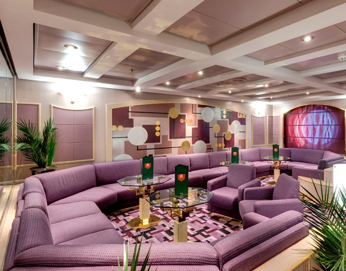 Luxurious lounge with purple seating and modern decor onboard an MSC cruise ship | MSC Cruises Luxurious lounge with purple seating and modern decor onboard an MSC cruise ship | MSC Cruises