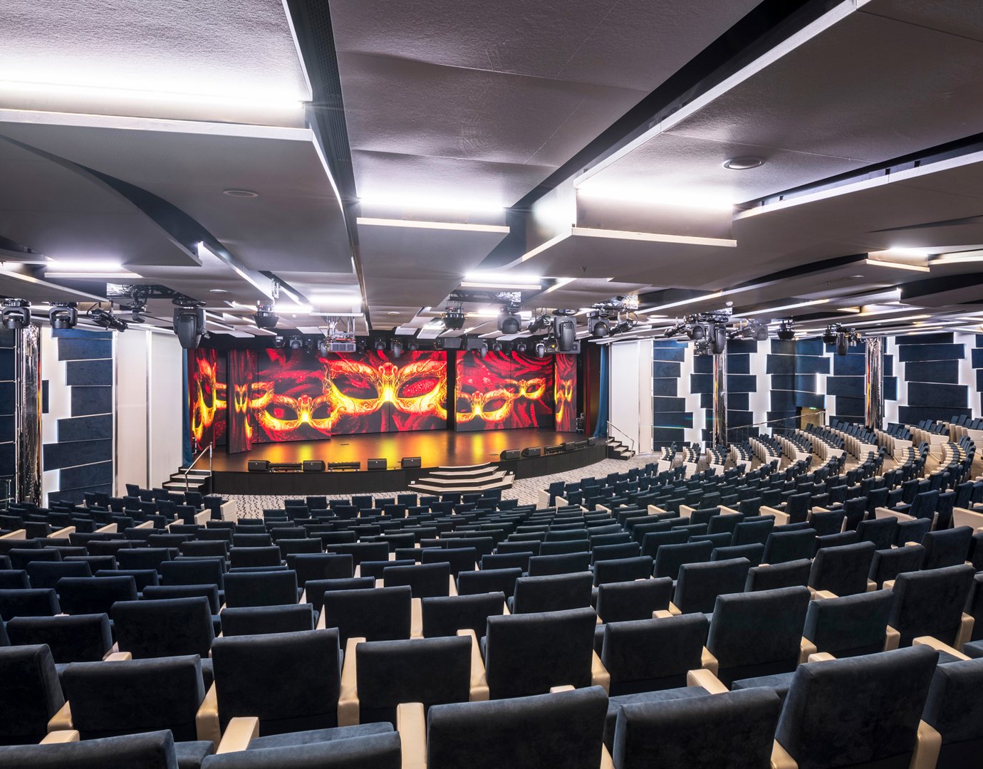 A modern theater with tiered seating and a vibrant stage on an MSC cruise ship | MSC Cruises A modern theater with tiered seating and a vibrant stage on an MSC cruise ship | MSC Cruises