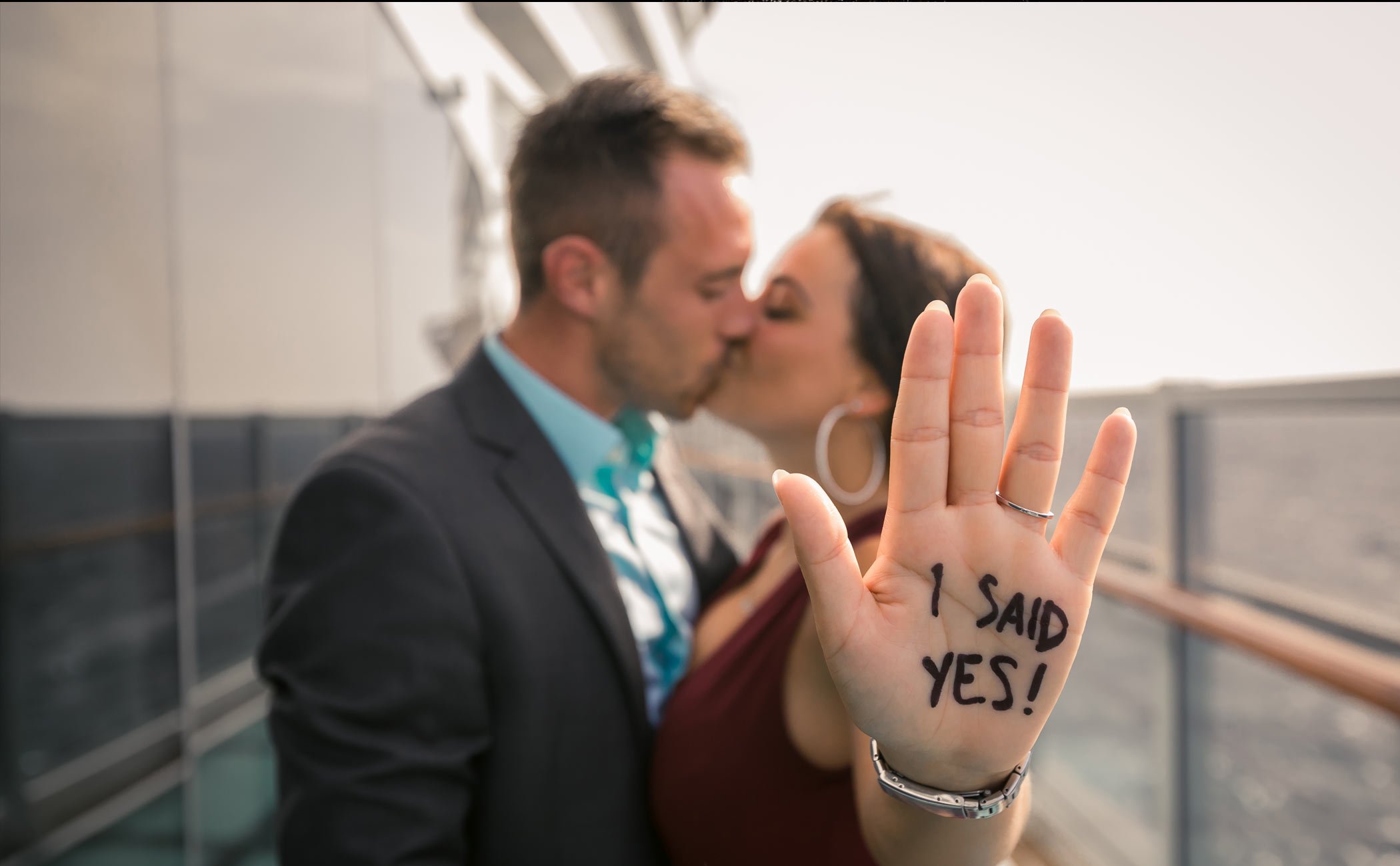 A couple celebrating an engagement on a cruise ship deck with 'I said yes!' written on her hand | MSC Cruises A couple celebrating an engagement on a cruise ship deck with 'I said yes!' written on her hand | MSC Cruises