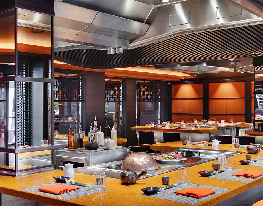 Elegant teppanyaki restaurant with modern decor and table settings onboard a cruise | MSC Cruises Elegant teppanyaki restaurant with modern decor and table settings onboard a cruise | MSC Cruises